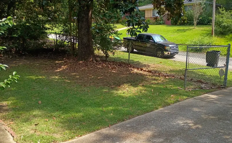 Pickup and mower trailer parked at the curb during a mowing stop